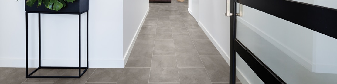Hallway with gray concrete look tile flooring.