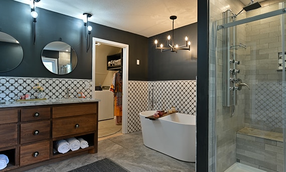 Bathroom with gray marble look floor tile & shower tile, soaker bathtub, white marble tile with gray rings backsplash, vanity with quartzite countertop.