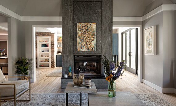 Family room fireplace with black soapstone on the hearth, abstract painting, and dark gray random linear mosaic porcelain tile on the façade.