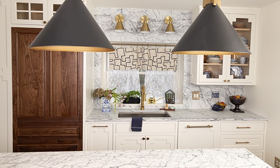Kitchen with sink and window, white cabinets, dark wood cabinets on the pantry, and white marble countertops and backsplash