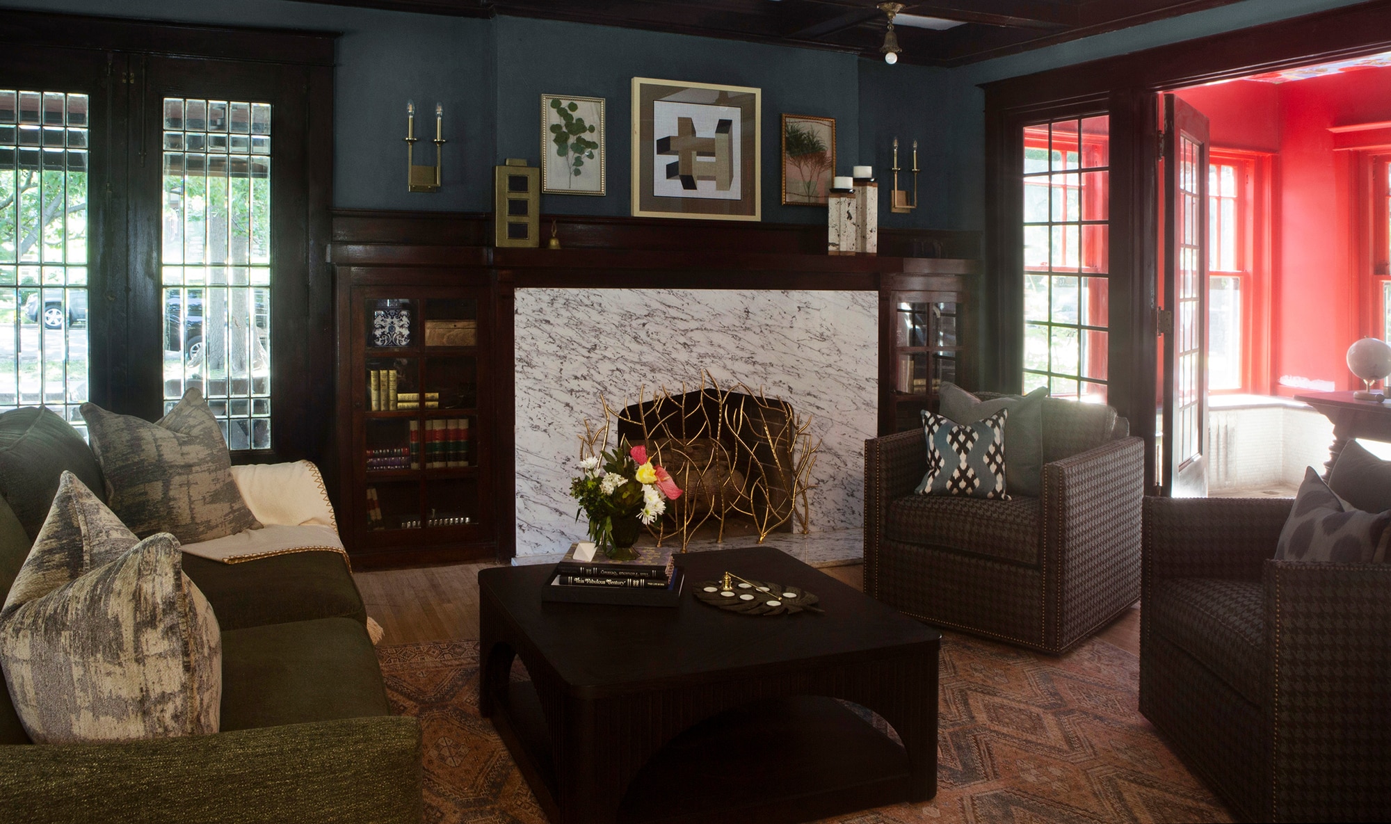 Living room with blue walls, dark wood accents, and a marble slab enveloping the fireplace.