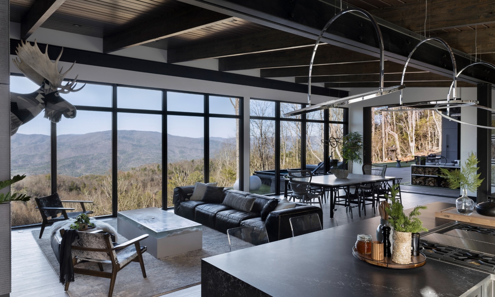 Chip Wade’s residential renovation, Pinhoti Peak, open kitchen, dining room, living room with black quartz countertops, and floor-to-ceiling windows.