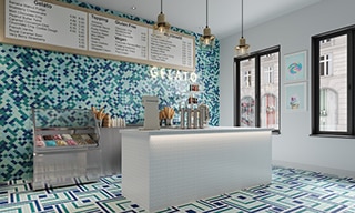 Ice cream parlor with light blue, navy, and teal arabesque mosaic wall tile, white, navy, teal, mint, and light blue mosaic floor tile, and white mosaic checkout counter.