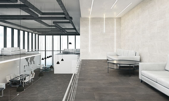 Corporate office with gray concrete tile flooring, off-white concrete wall tile, black conference tables & white chairs, and floor-to-ceiling windows.