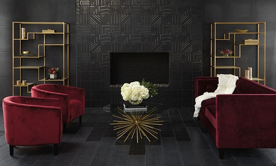 Elegant living room with black geometric tile on the fireplace surround, black wood look tile flooring, red velvet loveseat & chairs.