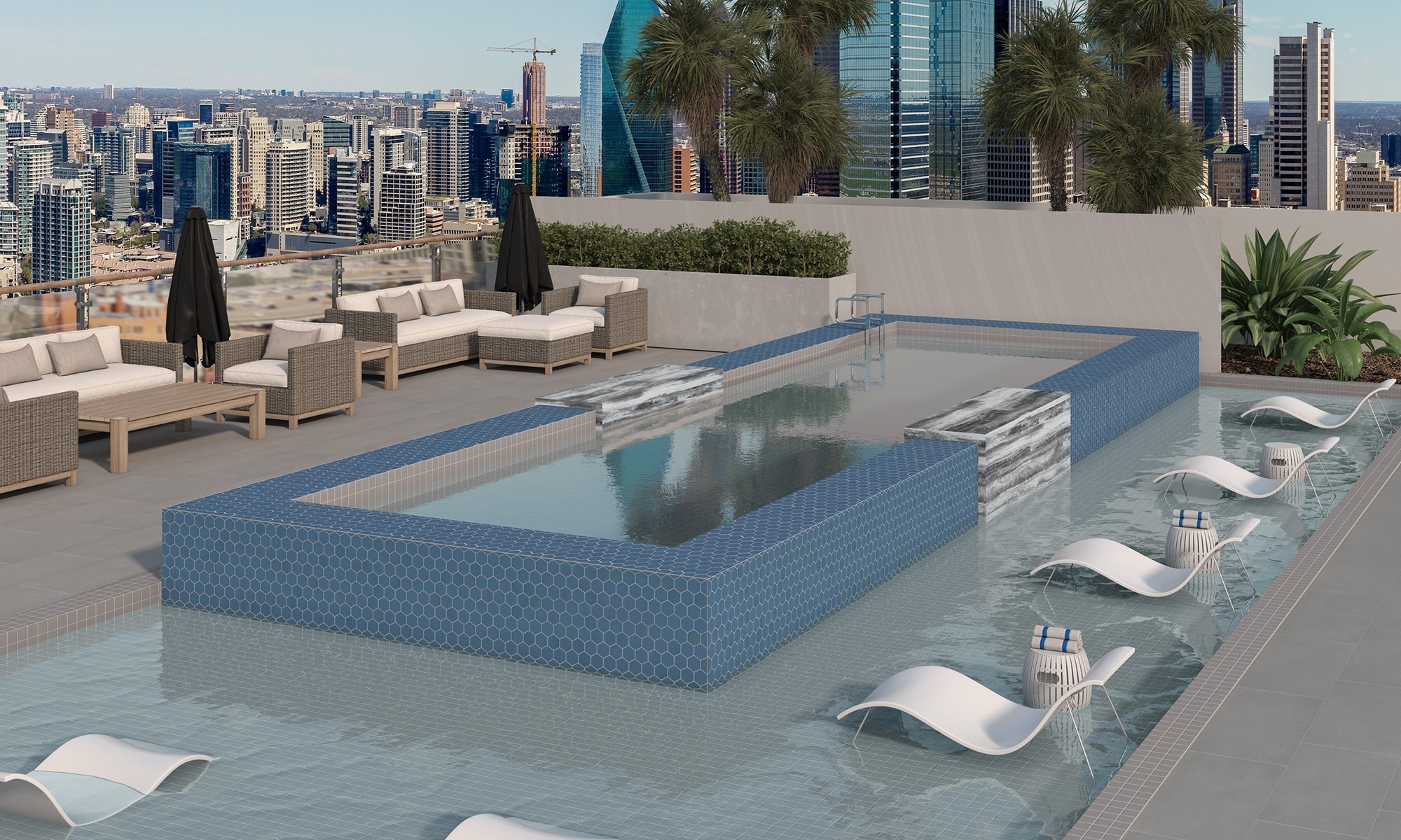 Rooftop pool with gray slip-resistance pool deck tile that looks like concrete, blue mosaic pool tile, gray mosaic tile pool border, and view of city skyline. 