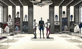 Athletic apparel store with off-white tile flooring with gold-colored embedded designs, lighted walls with shelves holding athletic clothing and mannequins.