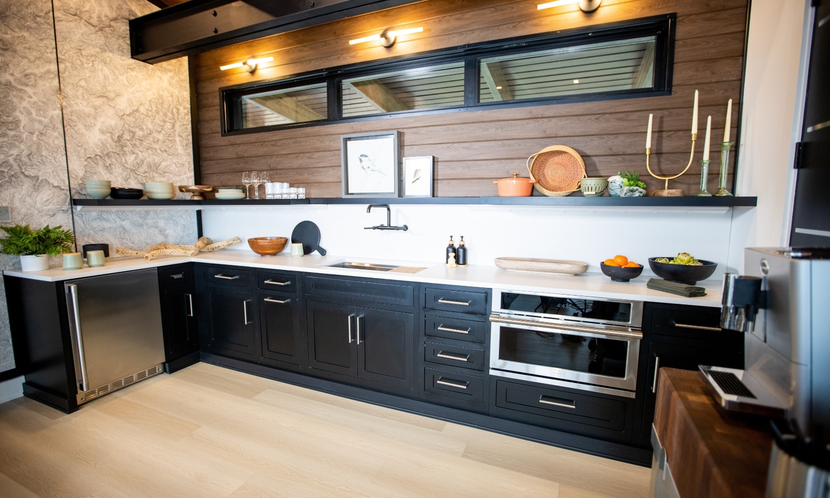 Chip Wade’s residential renovation, Pinhoti Peak, ADU kitchen with white quartz countertop and backsplash, natural wood shiplap, and black floating shelf.