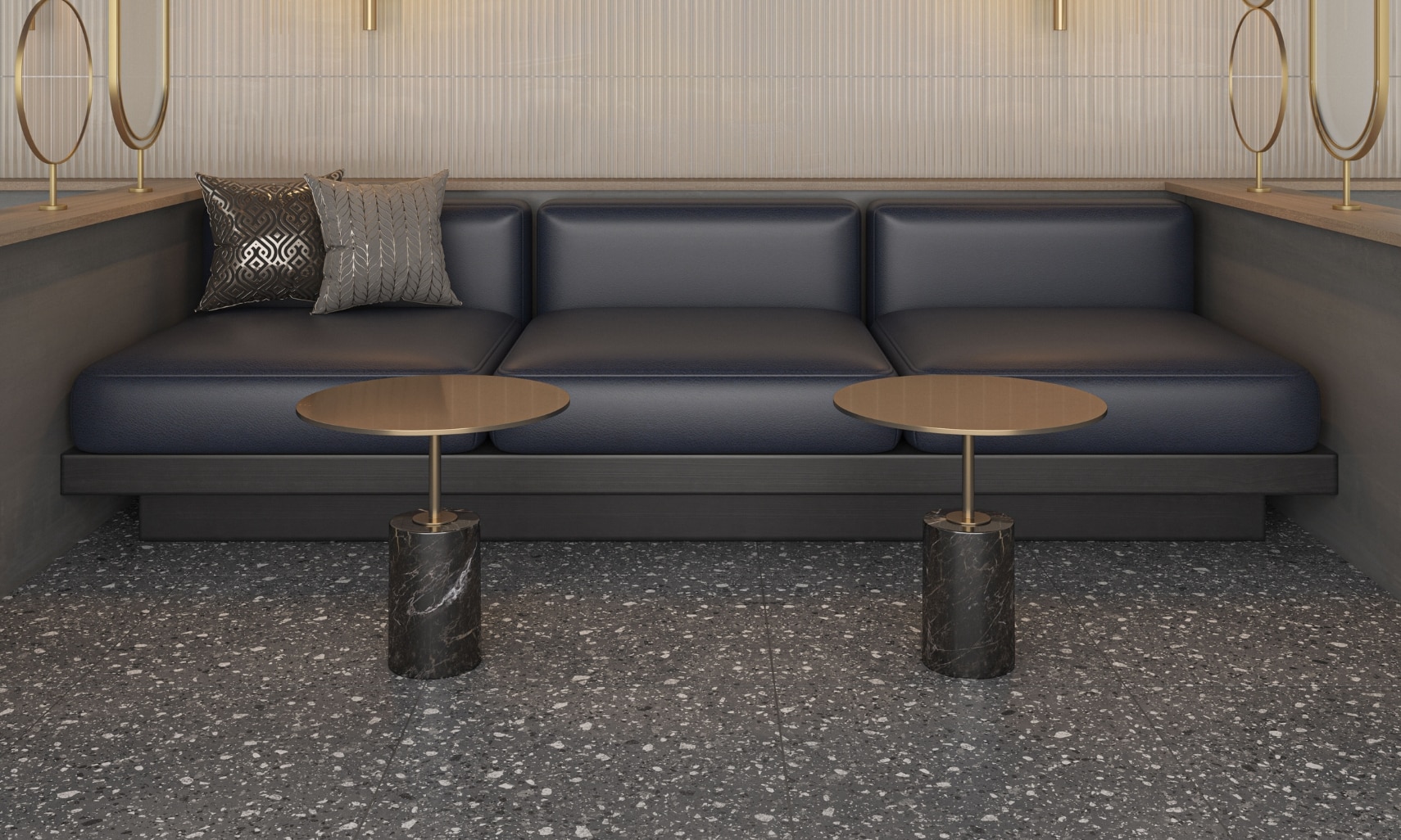 Lounge area with beige textured wall tile, black leather booth, two small metal and marble tables, and dark gray terrazzo look floor tile.