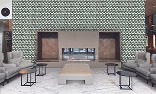Hotel lounge area with green and white glass mosaic tile feature wall with electric fireplace, white & gray marble-look floor tile, and leather chairs & ottoman.