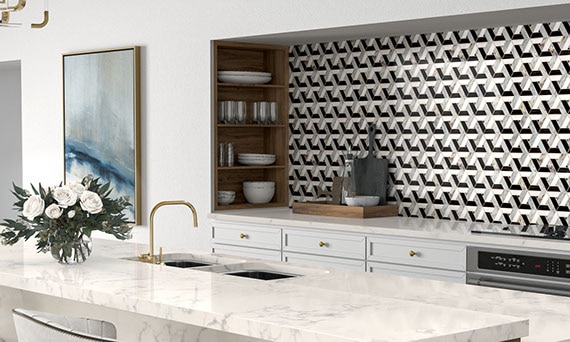 Modern kitchen with black, white, and gray glass mosaic backsplash, wood shelves, marble look quartz island with two sinks.