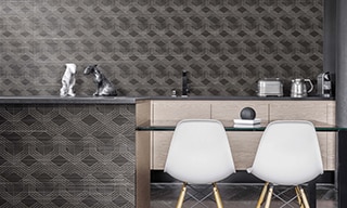 Restaurant with black & white patchwork slab tile on backsplash and waterfall island, white chairs, whitewashed wood lower cabinets.