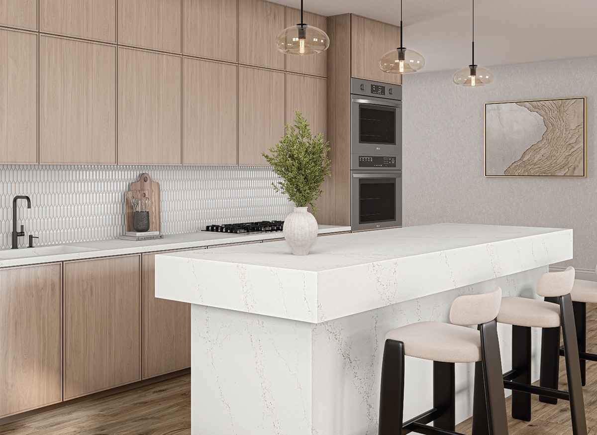 Kitchen with light wood cabinets, white mosaic backsplash, and center island with a white marble slab waterfall counter.