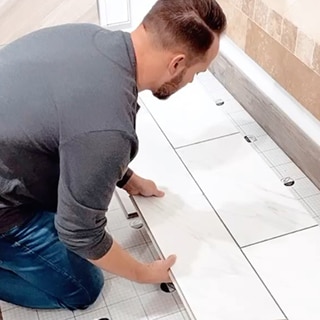 Instagram influencer Brad of Our Faux Farmhouse installing RevoTile - Marble Look tile.