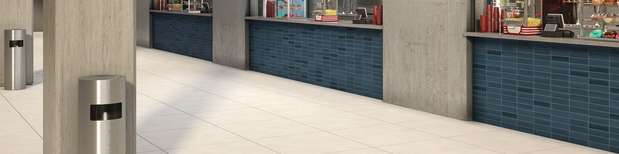 Baseball stadium concession stands with gray quartz countertops, blue subway wall tile, beige floor tile that looks like concrete.