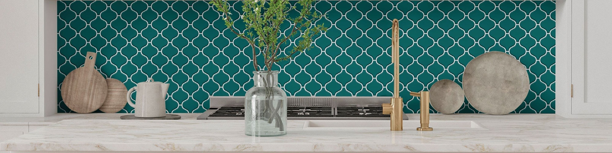 Bold kitchen décor with cream marble island countertop and bright teal arabesque mosaic tile backsplash.