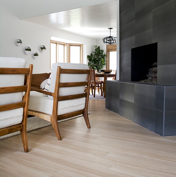 Close up of the living room with stone look tile fireplace and wood look tile floors and modern furnishings