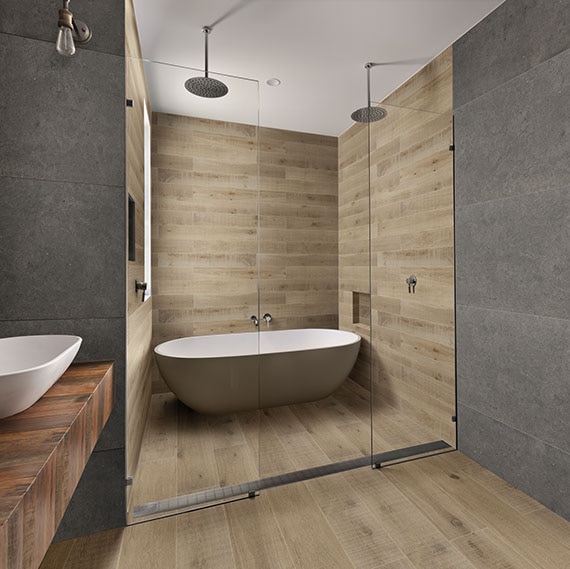Clean lined bathroom with large format stone look tile on walls and floor and a shower with wood look plank tile