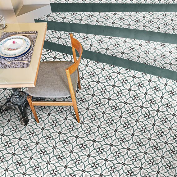 Bird's eye view of dining room floor with modern furnishings and encaustic floral pattern tile in blue and green