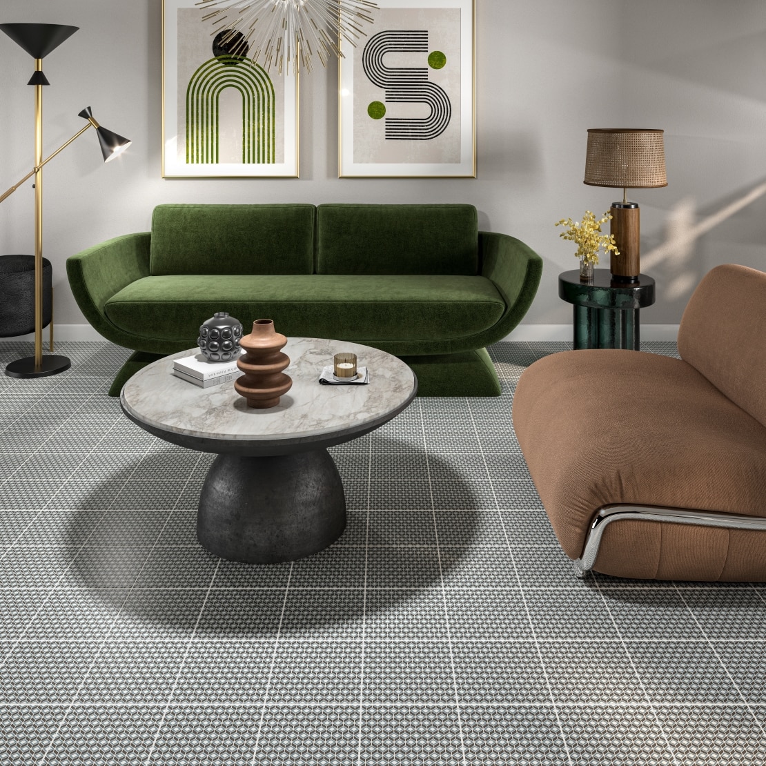 Retro inspired living room with a green couch, leather couch and patterned floor tile.