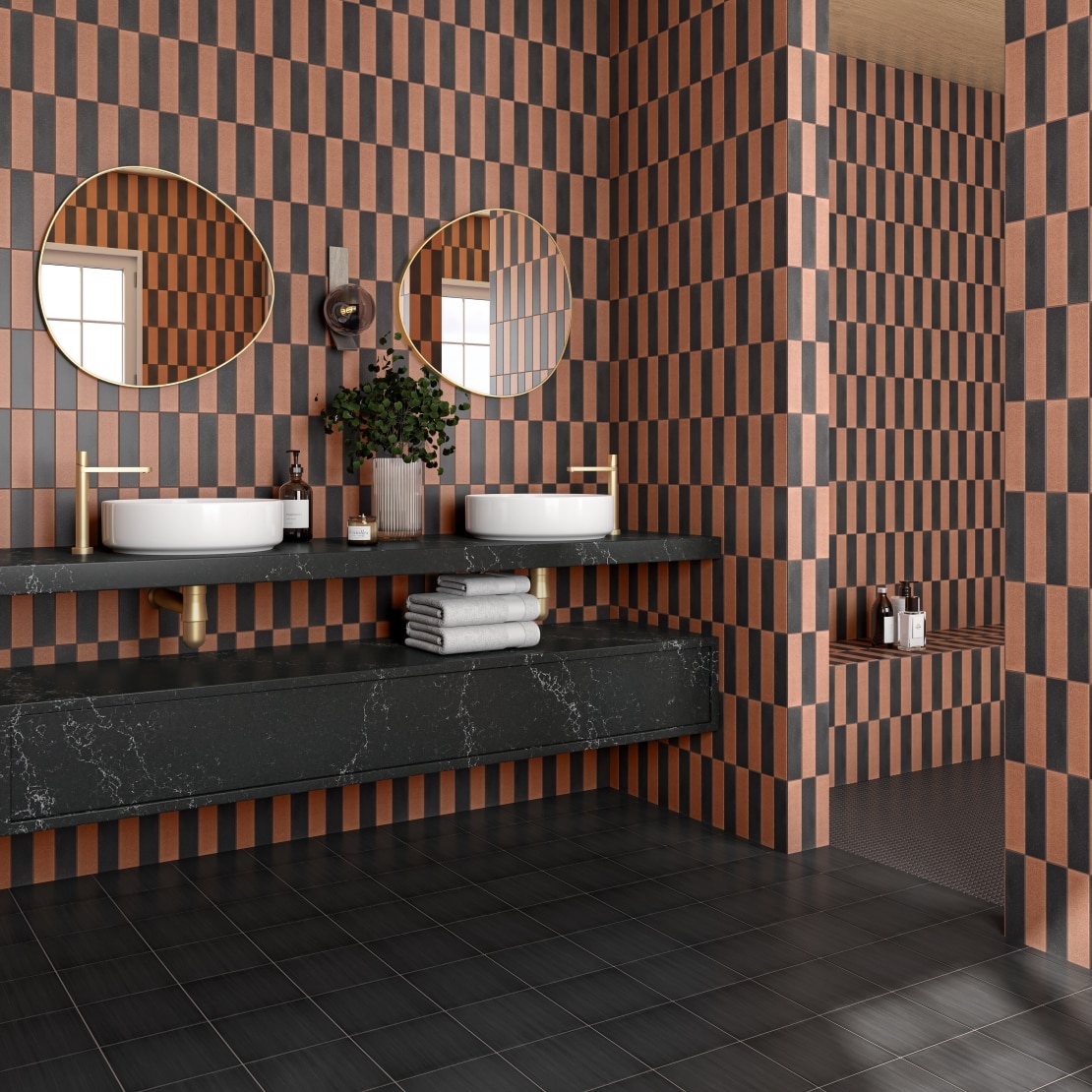 Contemporary bathroom with checkered walls, double sinks and black countertops.