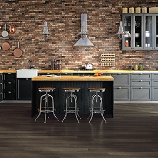 Industrial style kitchen with brick look tile on the backsplash with a large island with metal stools
