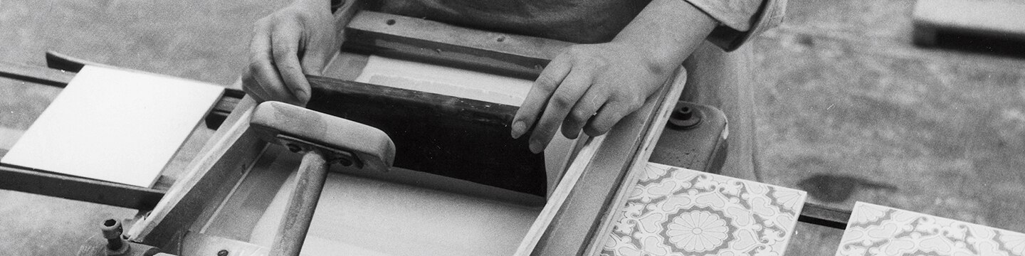 Tile manufacturing facility with artisan preparing tile for printing.