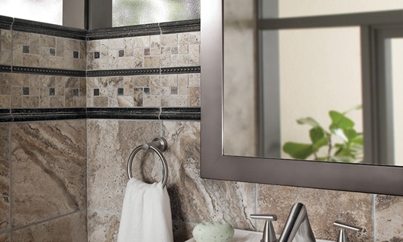 Bronze metal look tile behind a contemporary bathtub faucet with metal look bronze trim